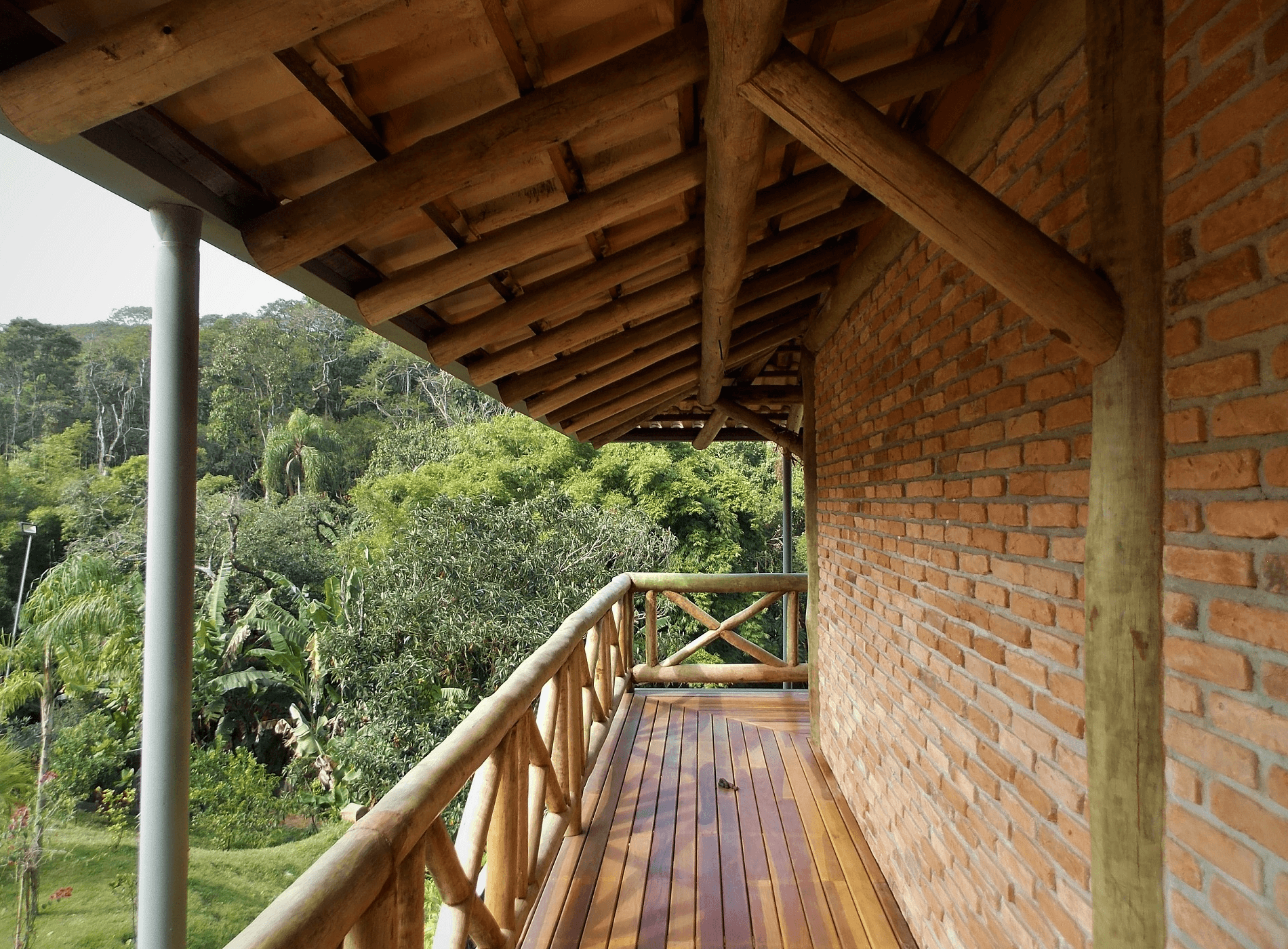 Mais uma imagem evidenciando a beleza das Casas Rústicas com Estrutura de Madeira. As varandas tiveram destaque neste Projeto. A Estrutura de madeira recebeu tijolos de demolição.