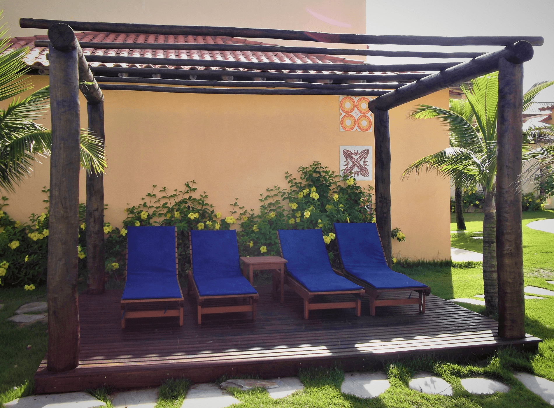 As cadeiras de praia instaladas no deck do pergolado criam o espaço perfeito para um banho de sol.
