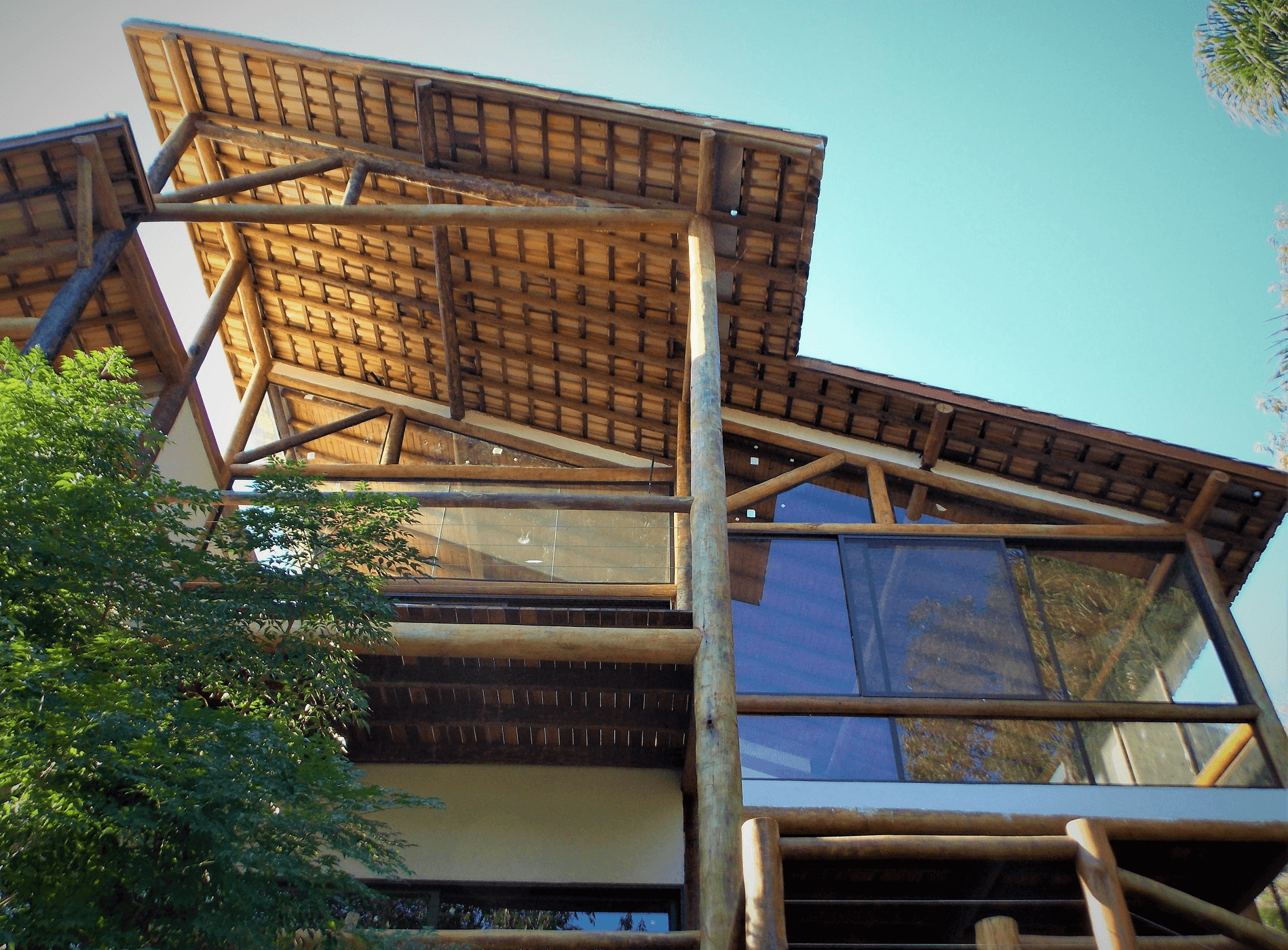 Neste ângulo Fachada com Estrutura de Madeira e Vidros. A Varanda Cobertura recebeu deck de Cumaru e telhado com madeira roliça aparente.   Cajamar – S.P.