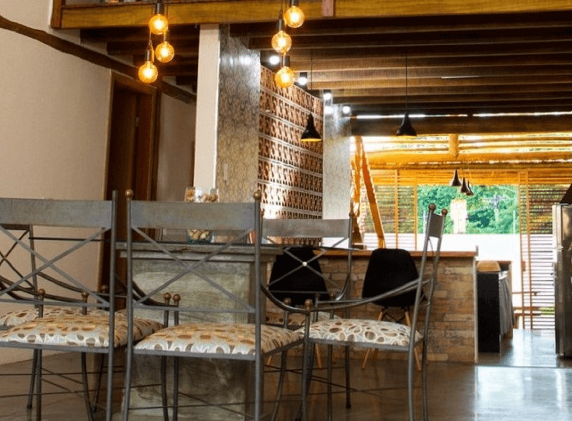 A parede com cobogós cerâmicos separa a área intima da casa enquanto que o balcão com tampo de madeira delimita o espaço da cozinha e a integra com a Área Social. Campinas – S.P.